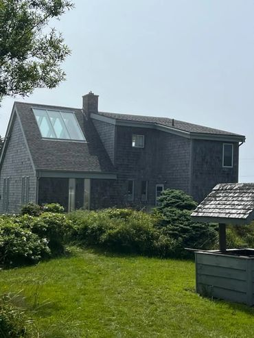 Rustic house with wooden shingles and skylight windows.