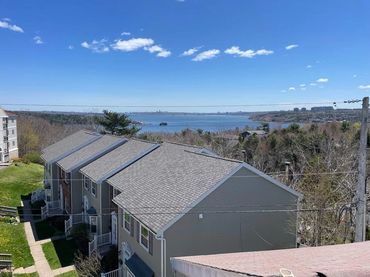 View of townhouses with a waterfront in the background.