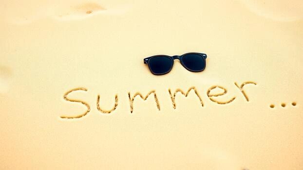 Sunglasses on sand with 'Summer...' written.