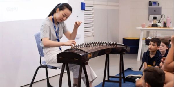 Woman playing a traditional string instrument for kids.