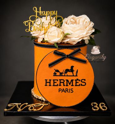 Elegant Hermes-themed birthday cake with flowers.