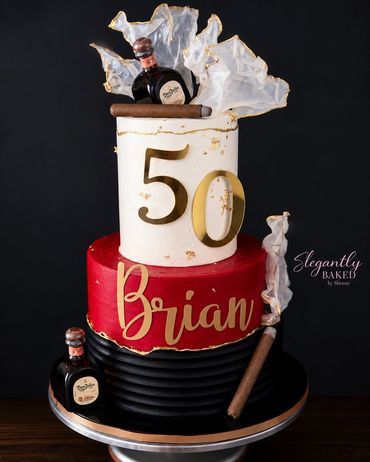 Elegant 50th birthday cake with cigars and whiskey decorations.