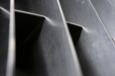 Close-up of sleek black metal panels with angular gaps.