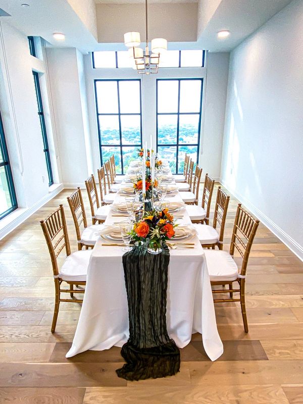 Elegant dining table lined with a dark green runner and autumn florals
