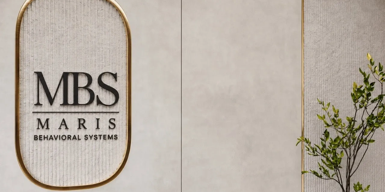 Elegant office wall with MBS Maris Behavioral Systems logo and decorative plant.