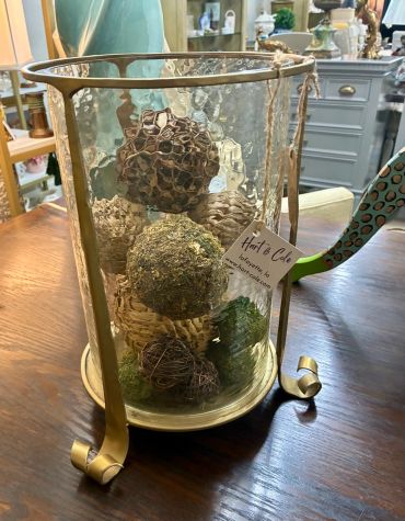 Decorative glass container with natural elements inside.