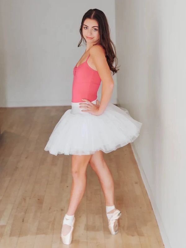 Young ballerina posing in tutu and pointe shoes.