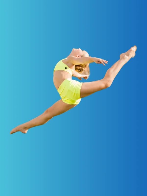 Dancer performing graceful leap in yellow outfit.