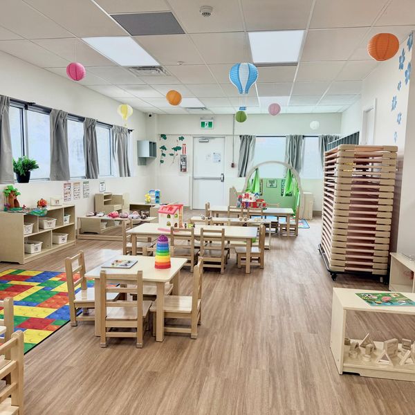 Bright and organized preschool classroom with wooden furniture.