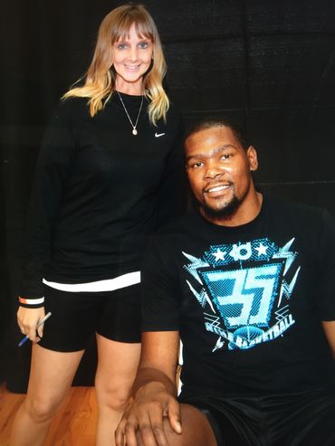 A smiling woman stands beside a seated man wearing a black shirt with the number 35.