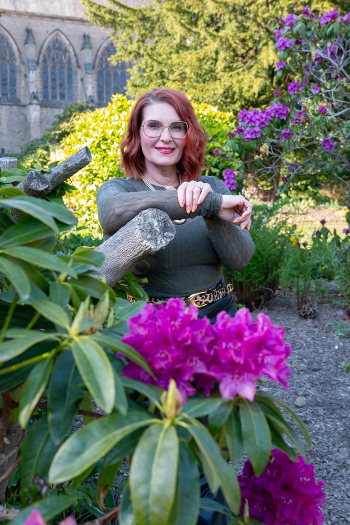 Emily stood in a garden with purple flowers.