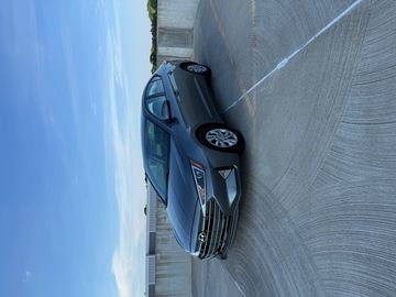 Gray Hyundai sedan parked on a rooftop under a clear blue sky.