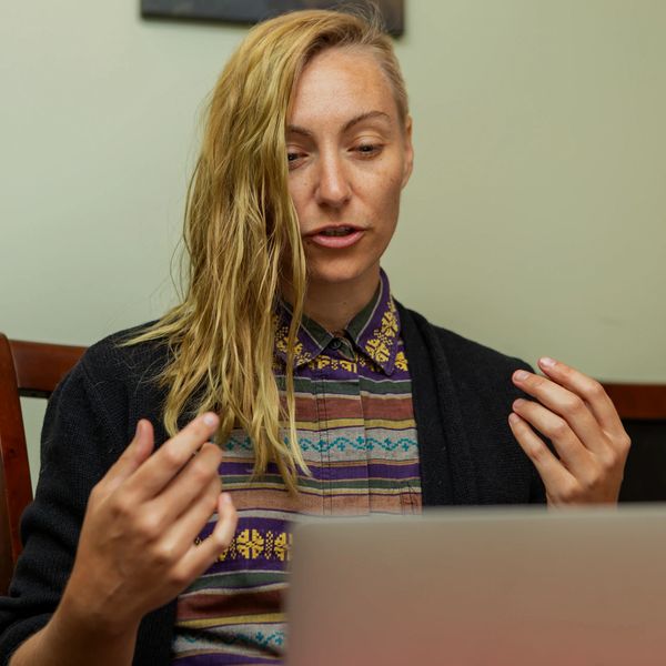 Woman talking and gesturing during a video call or online meeting.