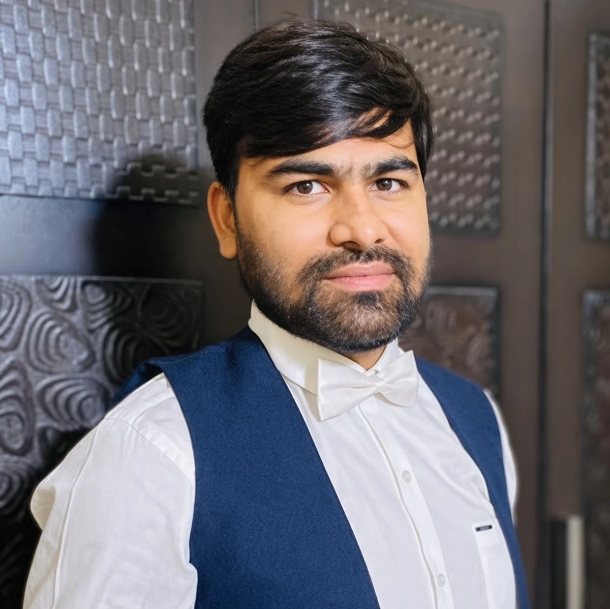 Man in formal attire with bow tie and vest.