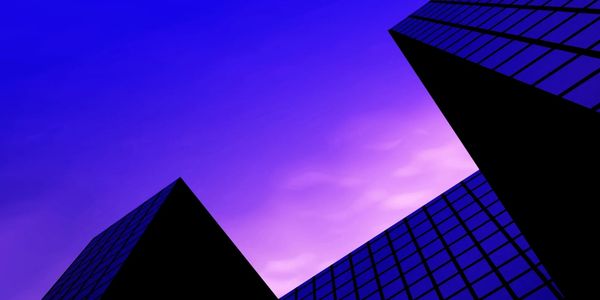 Silhouetted skyscrapers against a vibrant purple sky.