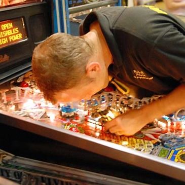 A man closely looking in a mirror filled with objects