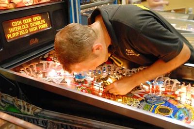 A man closely looking in a mirror filled with objects