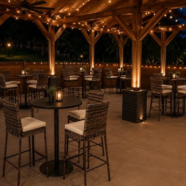 Outdoor patio with warm lighting and wicker chairs under a wooden pergola.