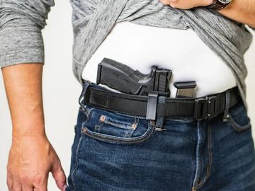 Person wearing a concealed handgun in a holster under their shirt.