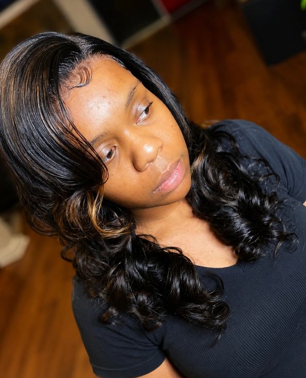 Woman with styled black curly hair wearing a black shirt.