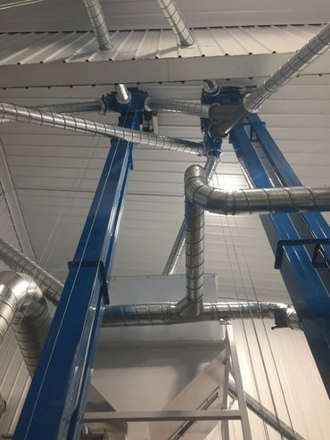 Industrial ceiling with blue beams and metallic pipes.