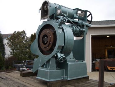 Large industrial machine part outside a garage.