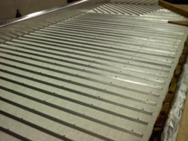 Close-up of parallel metal rods with holes.