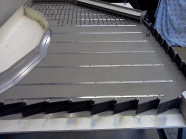 Metal piece with blades resembling a rake or comb.