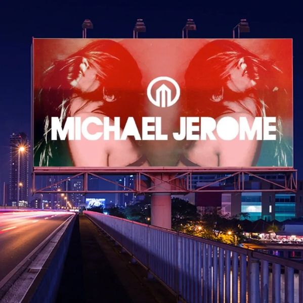 Nighttime billboard advertisement for Michael Jerome featuring mirrored images of a woman.