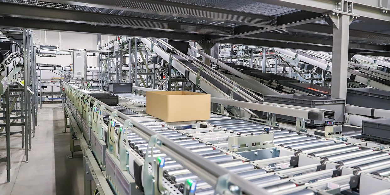 Automated conveyor system transporting a single cardboard box.