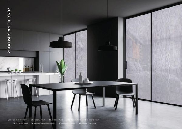 Modern dining room with ultra-slim sliding glass doors and minimalist black furniture.