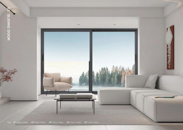 Modern living room with large sliding glass doors and forest view.