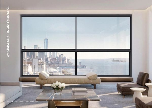 Modern living room with panoramic sliding window overlooking a cityscape and water.