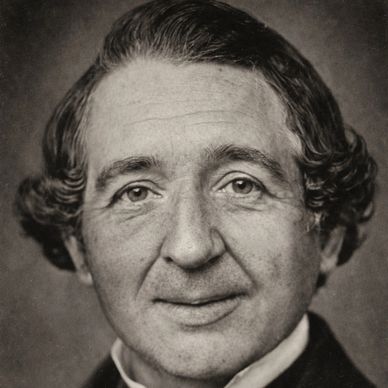 Black and white portrait of a man with styled hair and a slight smile.