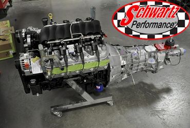 High-performance engine and transmission setup on a stand in a workshop.