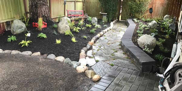 Landscape & Hardscape Design with flagstone pathway, Flowerbed with manor stone retaining wall.