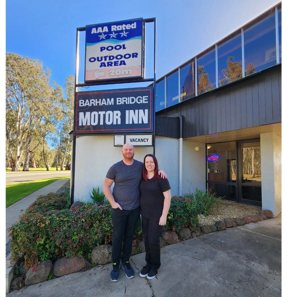 Hannah and Josh standing in front of motel sign