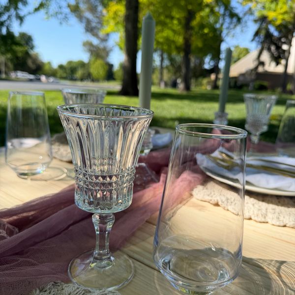 Elegant outdoor table setting with crystal glasses and candles.