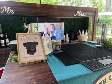 Wedding bar setup with "Mr &amp; Mrs" sign and photo.