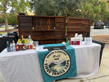 Outdoor mobile bar setup with drinks and supplies.