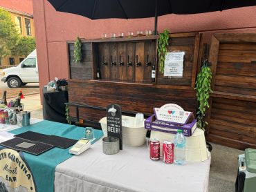 Outdoor bar setup with beers and soft drinks.