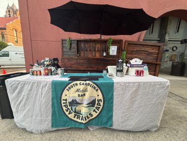 Mobile bar setup with South Carolina First Trails Taps banner.