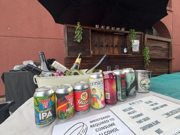 Assorted alcoholic drinks on ice with a sign about wristbands.