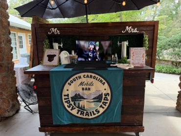 Rustic mobile bar setup with 'South Carolina Tipsy Trails Taps' banner.