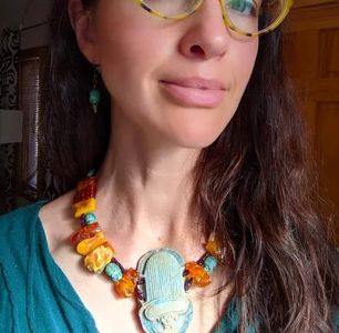 Woman wearing a colorful necklace with a large pendant.
