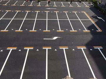 Empty parking lot with clearly marked spaces and directional arrows.