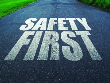 Safety First painted in large white letters on a road.
