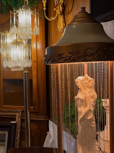 Elegant vintage lamps and a classical statue in a warm wooden interior.