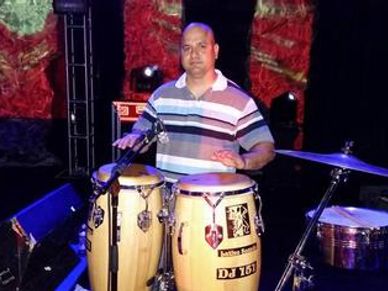Man playing conga drums on stage.