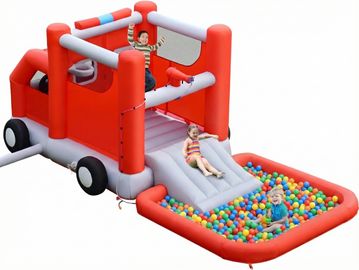 Château gonflable camion de pompiers rouge avec toboggan et piscine à balles où jouent trois enfants